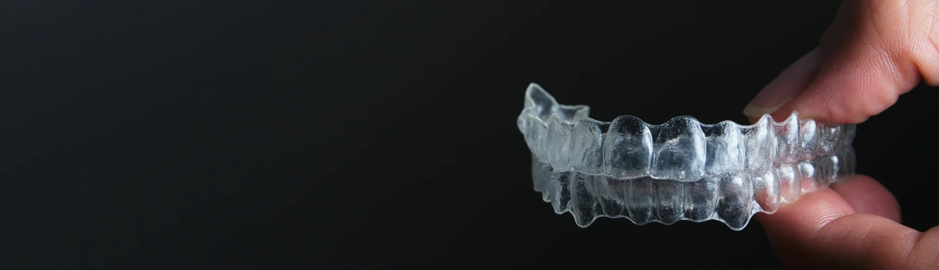 Paciente en Quito mostrando alineadores de ortodoncia invisible en una consulta odontológica especializada.Ortodoncia invisible en Quito | Blog Clínica Dentalbanner